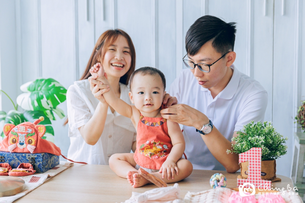 爸爸媽媽為周歲寶貝穿上抓周服飾